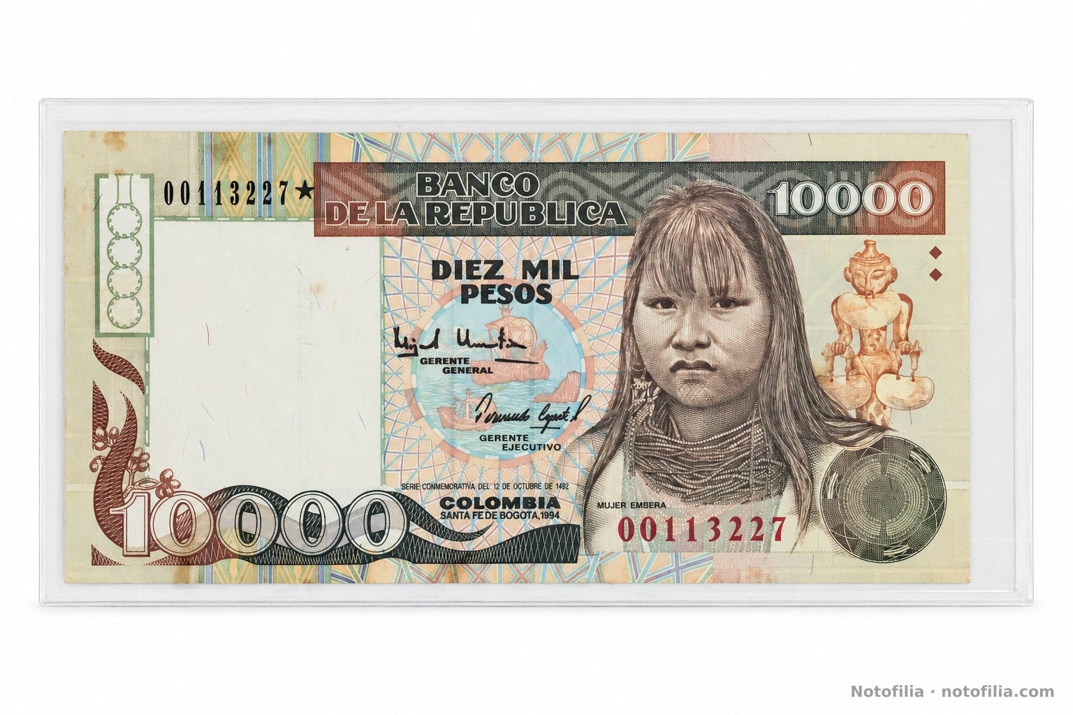 Face of the 10,000 pesos, Pick 437A / TBB B980az: Emberá woman, Quimbaya poporo, the date 1994, and serial 00113227 with a replacement star.