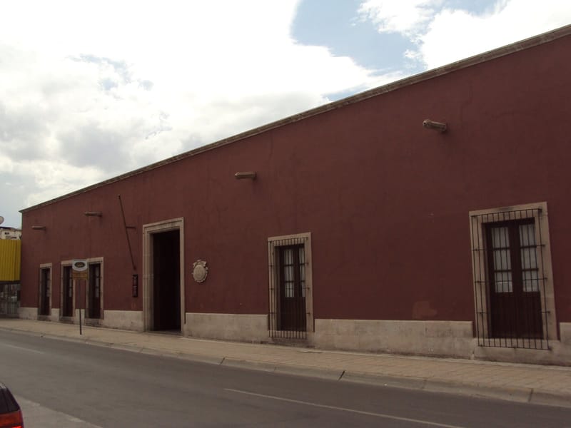 Fachada del Museo Casa Juárez en Chihuahua, con balcones y bandera de México
