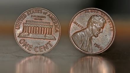 Anverso y reverso de un centavo Lincoln Memorial de 1969 sobre una superficie oscura