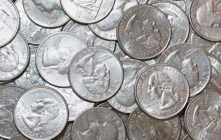 A collector’s hands reviewing U.S. 25-cent coins