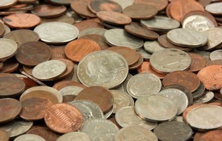 A pile of circulated U.S. coins — cents, nickels, dimes, and quarters — in close-up