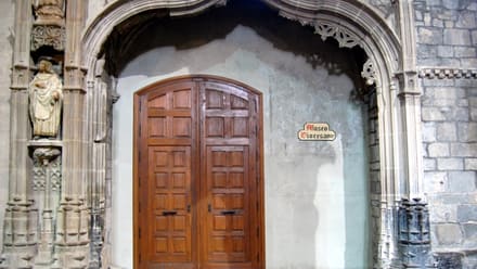 Puerta de madera bajo un arco gótico con el rótulo Museo Diocesano en Jaca