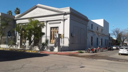 Neoclassical façade of the Paysandú Casa de Cultura, with columns, pediment, and Uruguayan flag