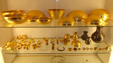 Cuencos y brazaletes de oro del Tesoro de Villena en una vitrina de museo