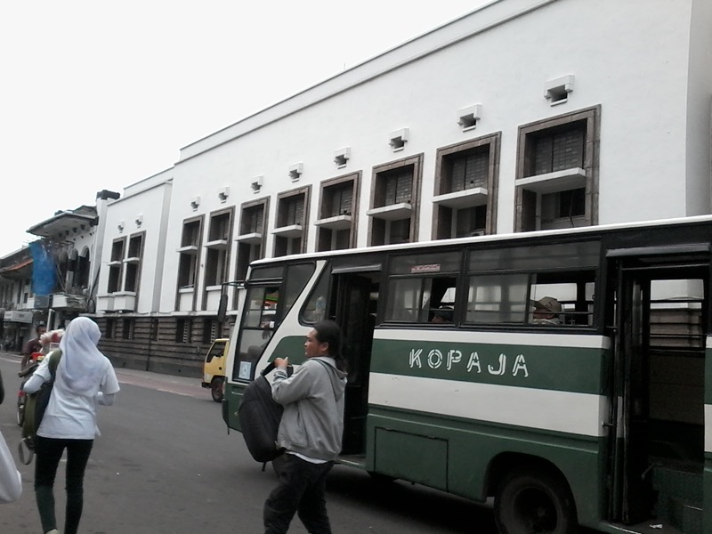 Fachada blanca del Museo del Banco de Indonesia en Kota Tua, Yakarta, con un autobús verde en primer plano